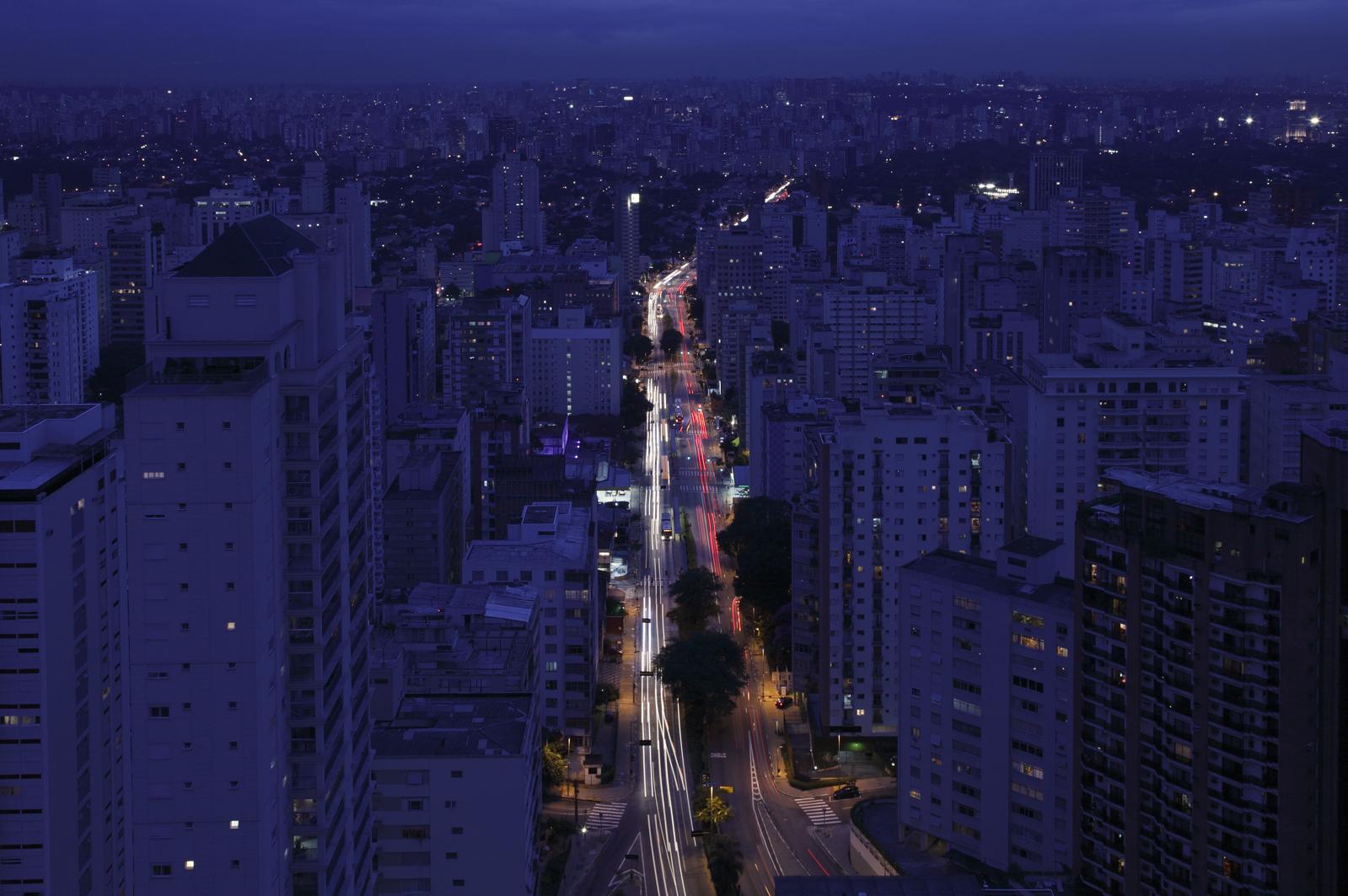 Night view of Avenida Paulista in São Paulo, lined with high-rises and streaks of traffic lights