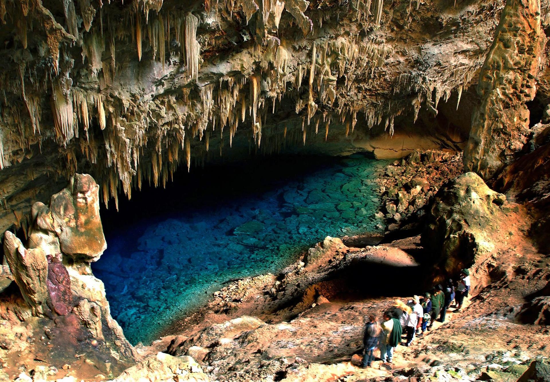 Visitors descending into the Gruta do Lago Azul in Bonito, a cave with a turquoise underground lake and stunning stalactite formations