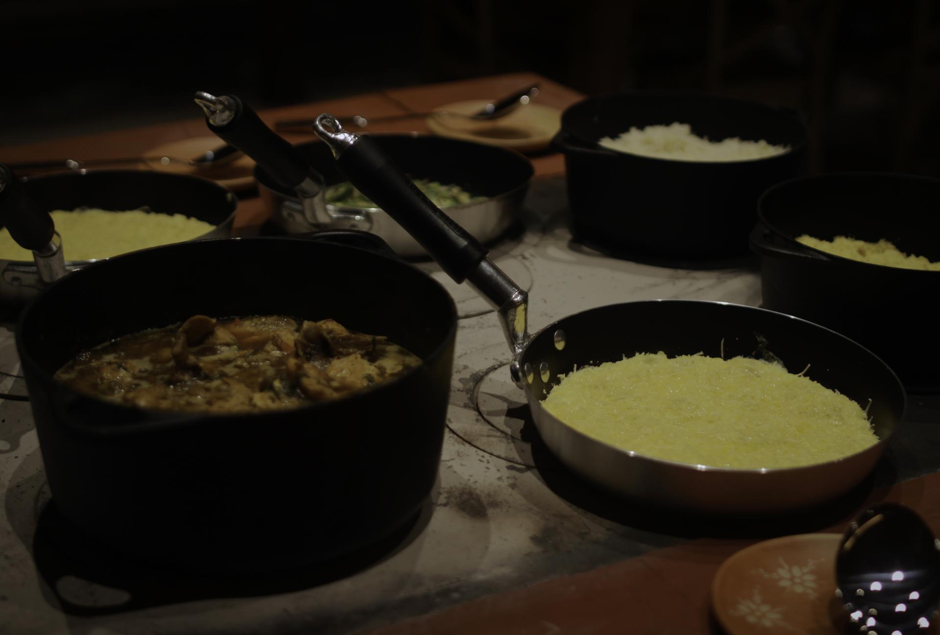 Brazilian dinner with polenta and traditional side dishes Traditional Brazilian dish served in black pots, accompanied by polenta and other side dishes.
