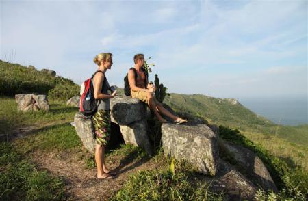 A couple sitting on the mystic rocks in Florianopolis