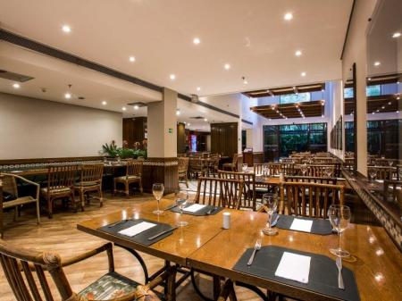 Tables and chairs in wooden and bamboo design at the Restaurant of Hotel Estanplaza Paulista