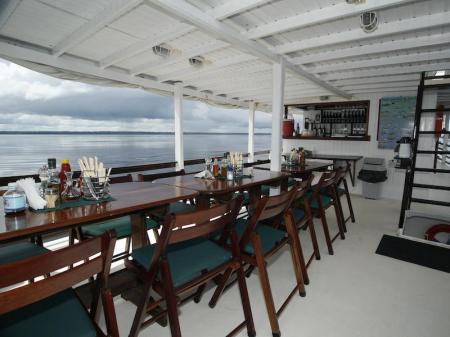 An restaurant with a beautiful view over the water on the deck of an Amazon Clipper Boat