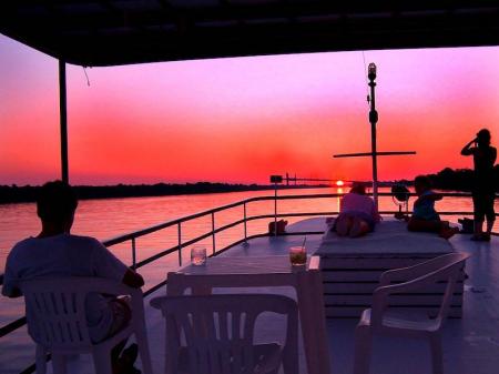 Visitors enjoying a beautiful sunset on the top deck of an Amazon Clipper