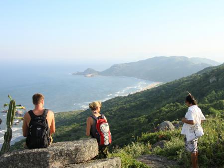 Three visitors enjoying the view during a hike in Florianopolis