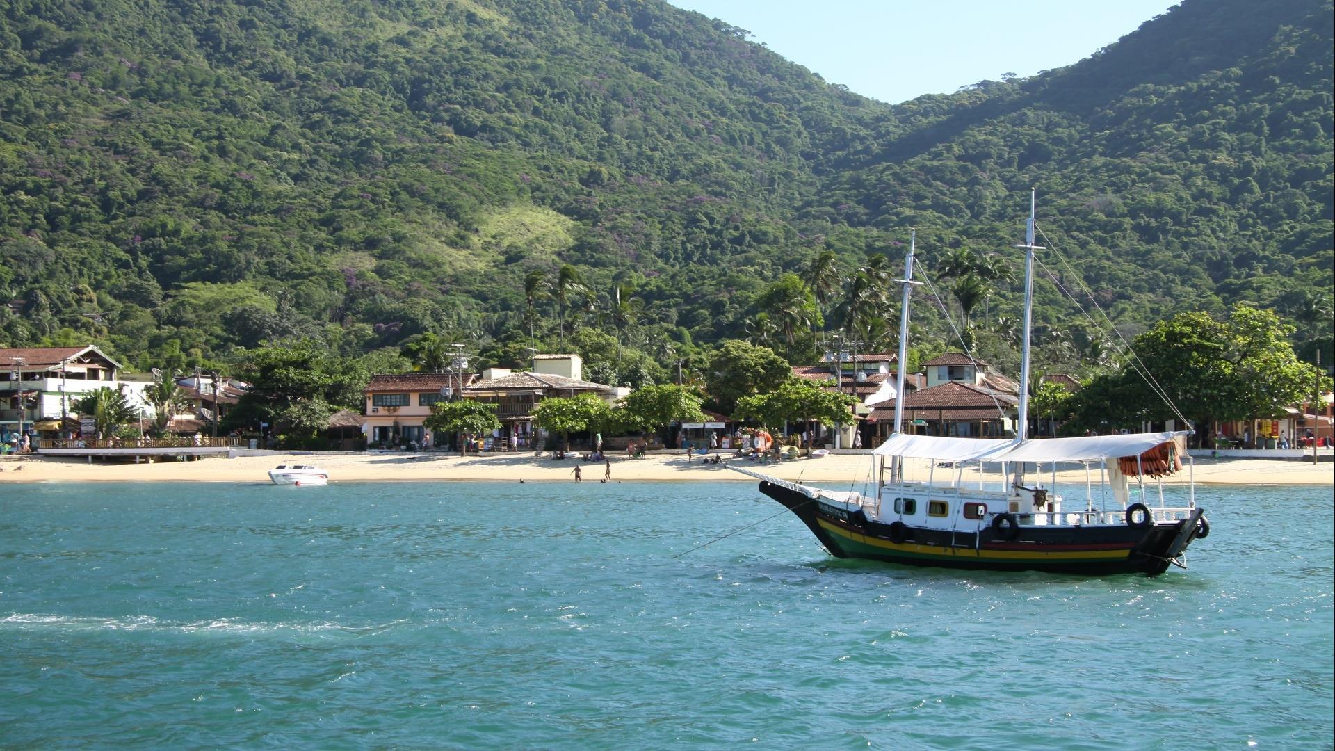 A typical boat in front of a beach and Atlantic Rainforest of Ilha Grande, Rio de Janeiro