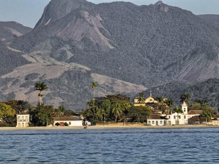 A nice view from a boat on colonial buildings in front of the mountains