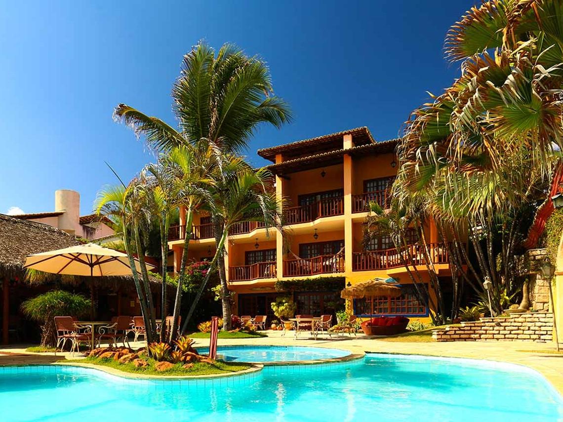 Pool area with palm trees in front of the superior Hotel Manary Praia in Natal