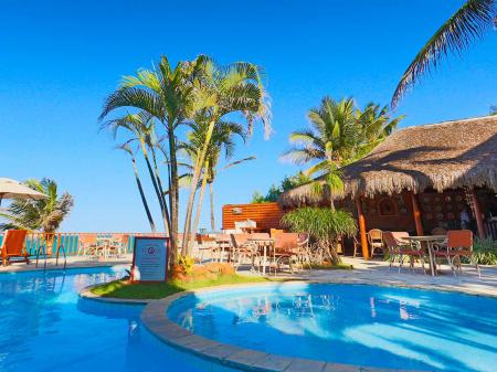 Outdoor pool area and palm trees in front of the superior Hotel Manary Praia