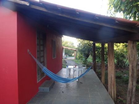 A red Bungalows with varanda and hammock at Pousada Fazenda Rio Negro in Nilo Pecanha