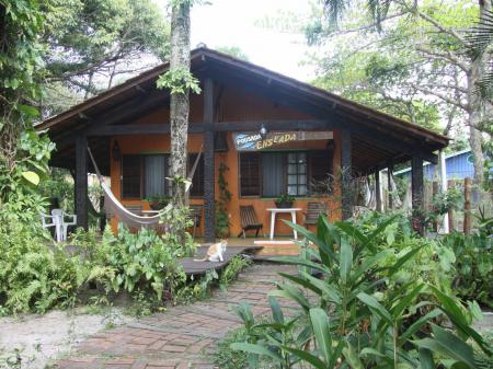 Typical wooden cottage with hammocks at Pousada Enseada das Conchas