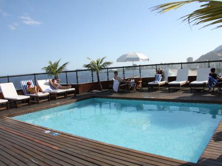 A lounge with seats, tables, and a bar at Hotel Porto Bay Rio Internacional