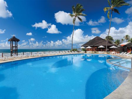 Pool area with palm trees at Hotel Armacao