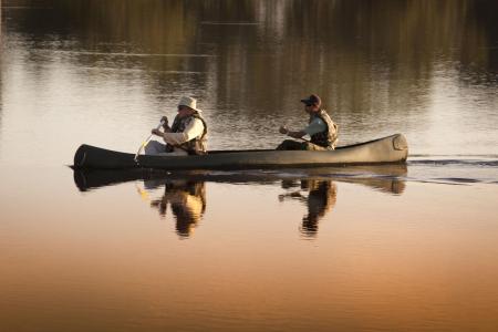 A guide and a visitor in a canoe during a trip near by Caiman Lodge