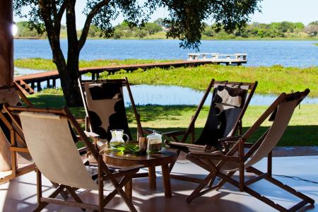 A table with four chairs and a nice view on the river at Caiman Lodge