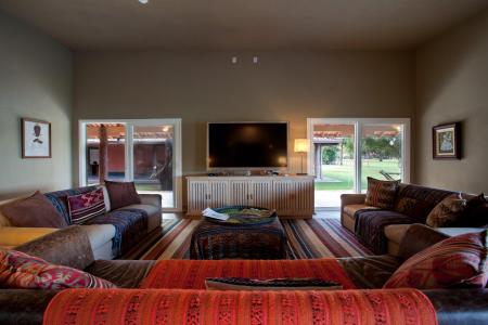 Living room with TV and Sofas, at Caiman Lodge