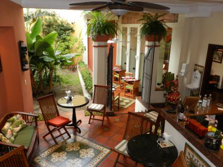 The bar with seats, tables and an outdoor area at Hotel Casa do Amarelindo