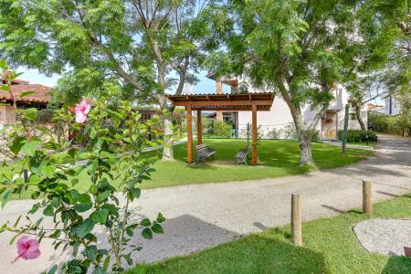 Lush green gardens with flowers and seats at Pousada Ilha Faceira in Florianopolis