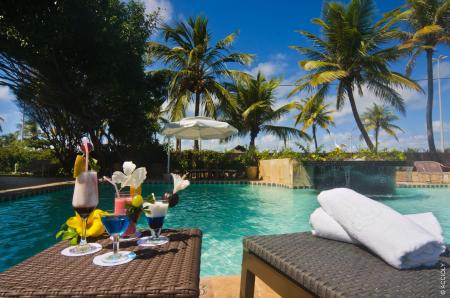 A nice pool with palm trees and tropical drinks of Hotel Celi Aracaju
